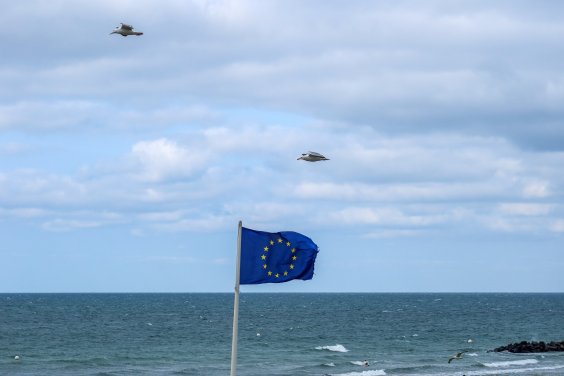 Eine Fahne der Europäische Union weht im Wind am Ostseestrand bei Schönberg.