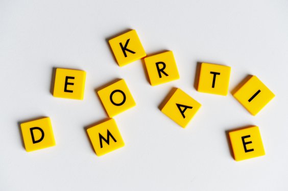 Farbfoto: Aus mehreren gelben Buchstabensteinchen wurde das Wort "Demokratie" gelegt. 