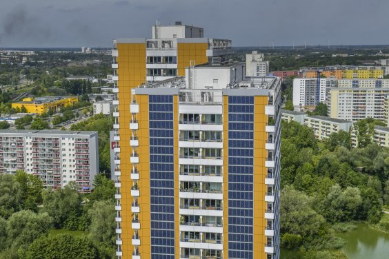 Photovoltaik-Anlage an der Gebäudefront von einem gelben Hochhaus am Helene-Weigel-Platz in Berlin-Marzahn. 