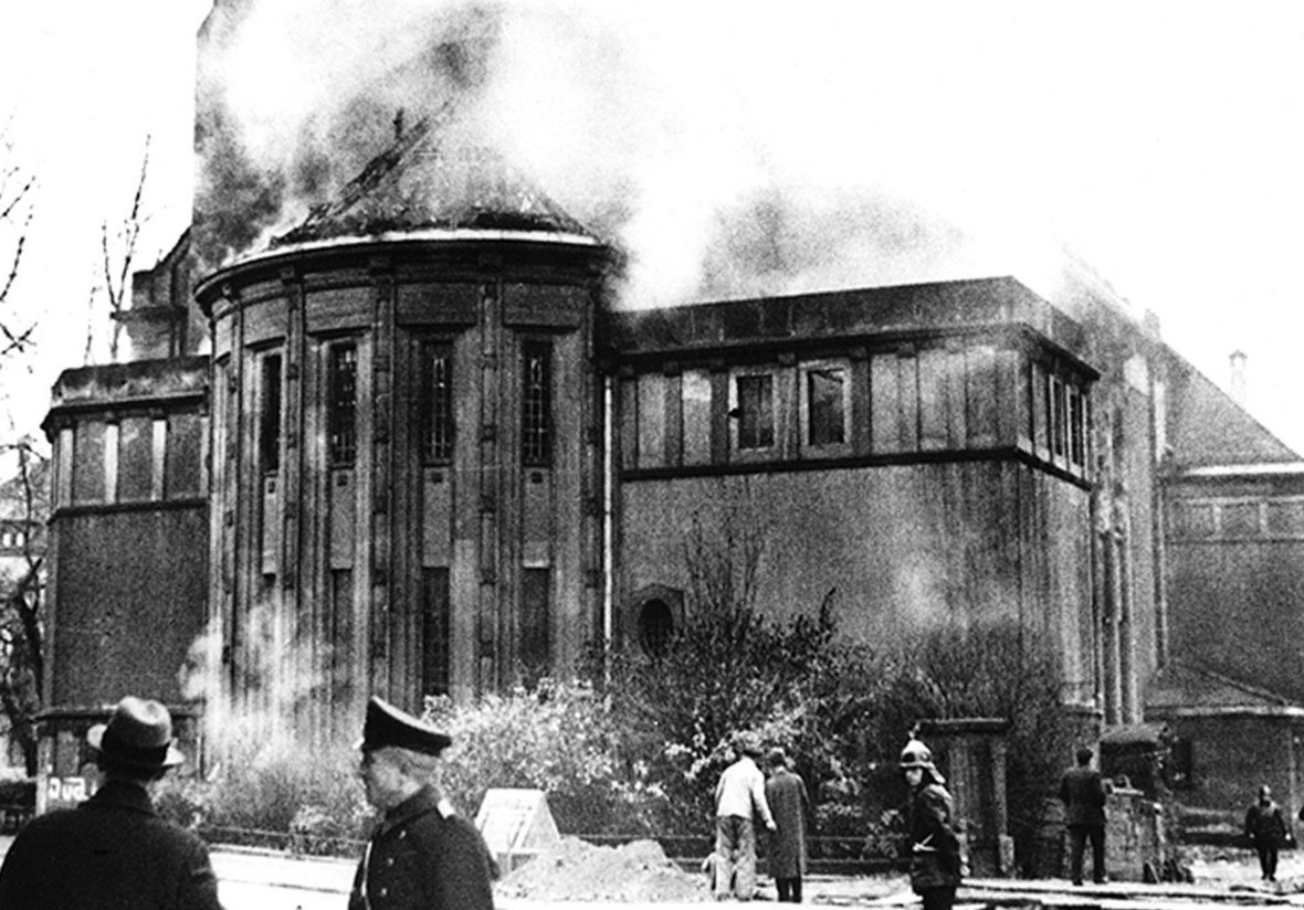 9. November 1938: Feuerwehrleute vor brennender Synagoge.