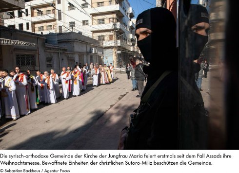 Farbfoto: Auf dem Foto ist eine christliche Prozession zu sehen, die von bewaffneten Einheiten der christlichen Sutoro-Miliz beschützt wird.