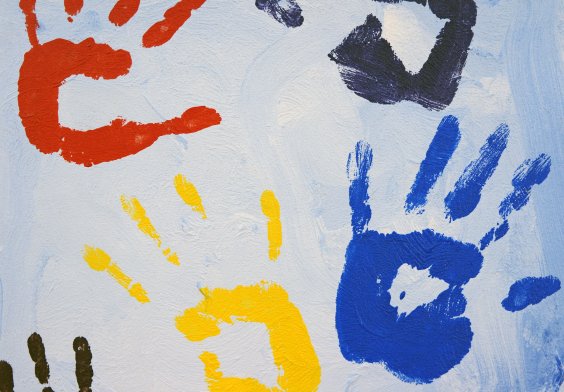 Auf weißem Hintergrund sind mehrere Handabdrücke in rot, schwarz, blau und gelb zu sehen.