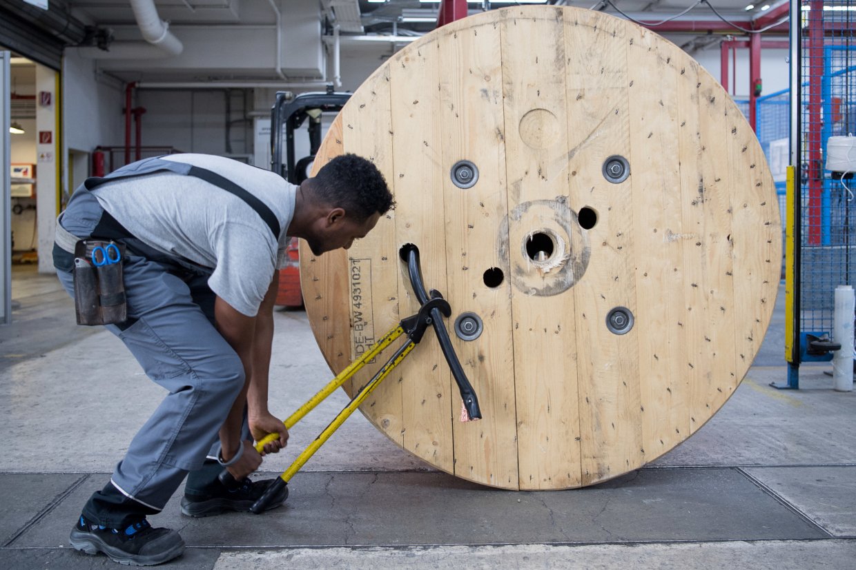 Geflüchteter aus Eritrea bei der Arbeit bei einem Kabelhersteller in Baden-Württemberg